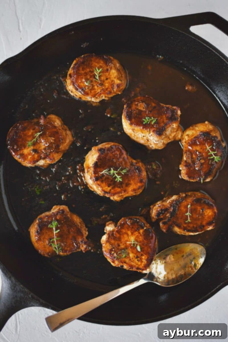 Chef basting Pork Tenderloin Medallions in the rich pan sauce after returning them to the skillet, enhancing flavor and moisture.