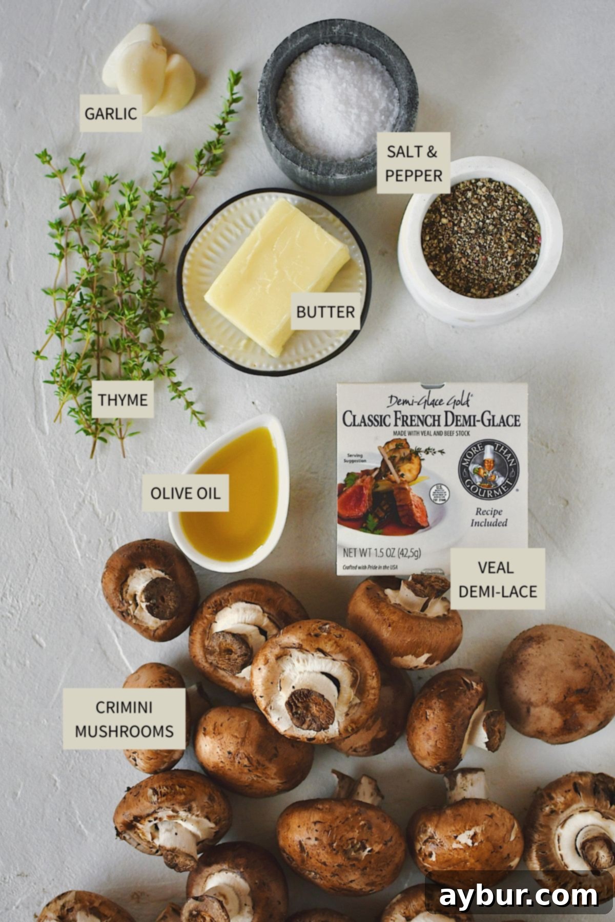 All the essential ingredients laid out to make the perfect Steakhouse Mushrooms, including fresh crimini mushrooms, butter, garlic, thyme, and a container of demi-glace.