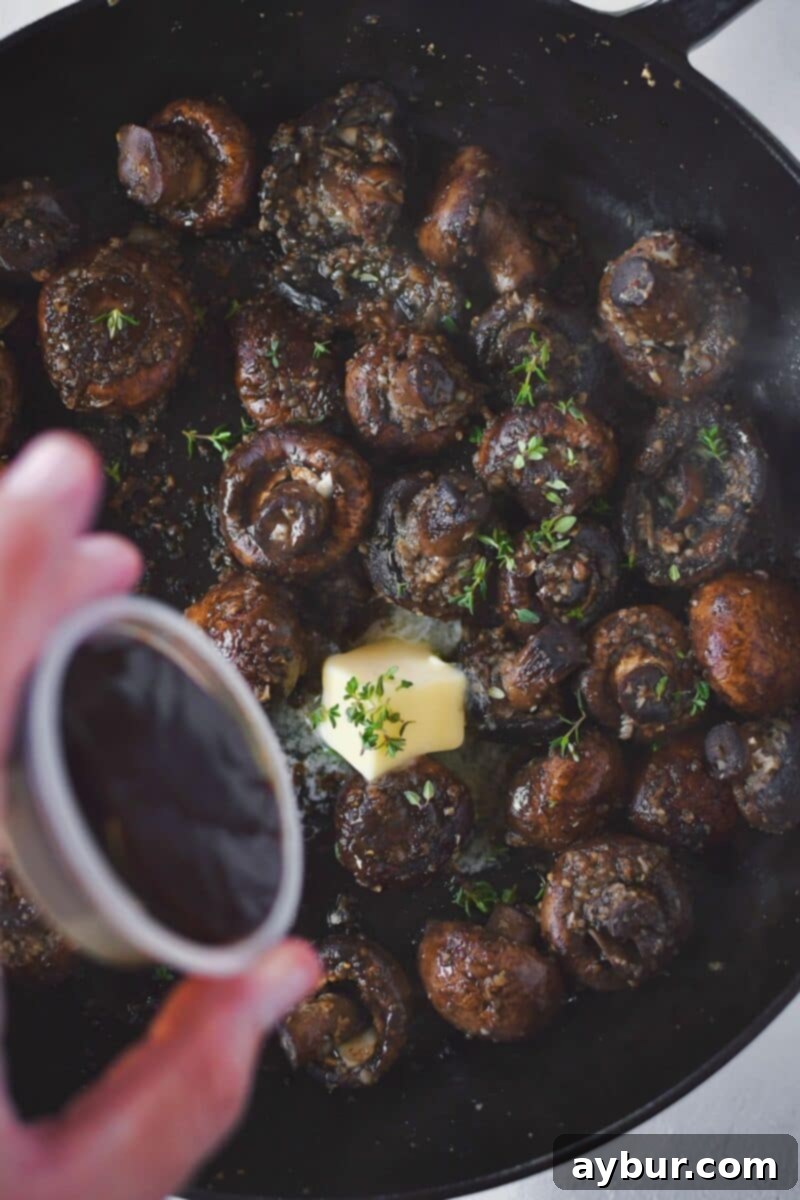 Mushrooms after steaming, with the lid removed. Half the butter and the demi-glace paste are being added along with water and seasonings, ready to form the rich sauce.