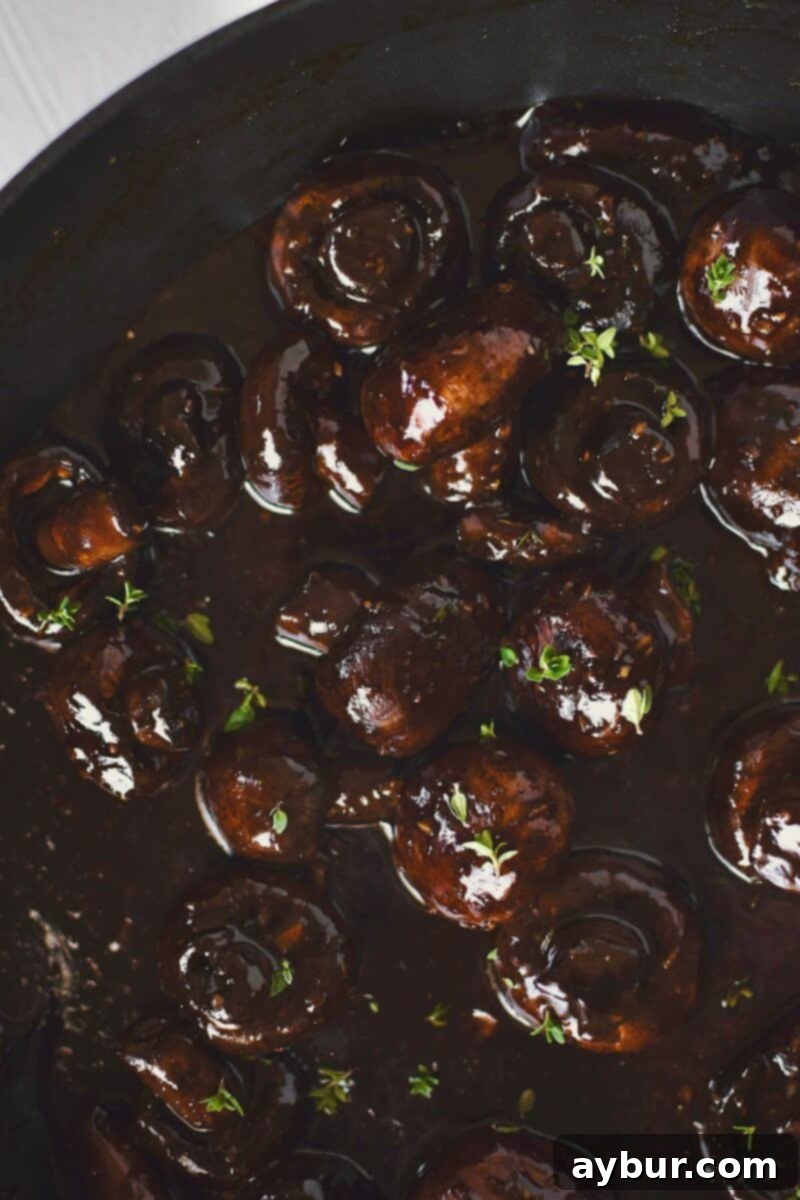 The rich demi-glace sauce has been stirred into the mushrooms and brought to a boil, reducing to coat each mushroom beautifully.