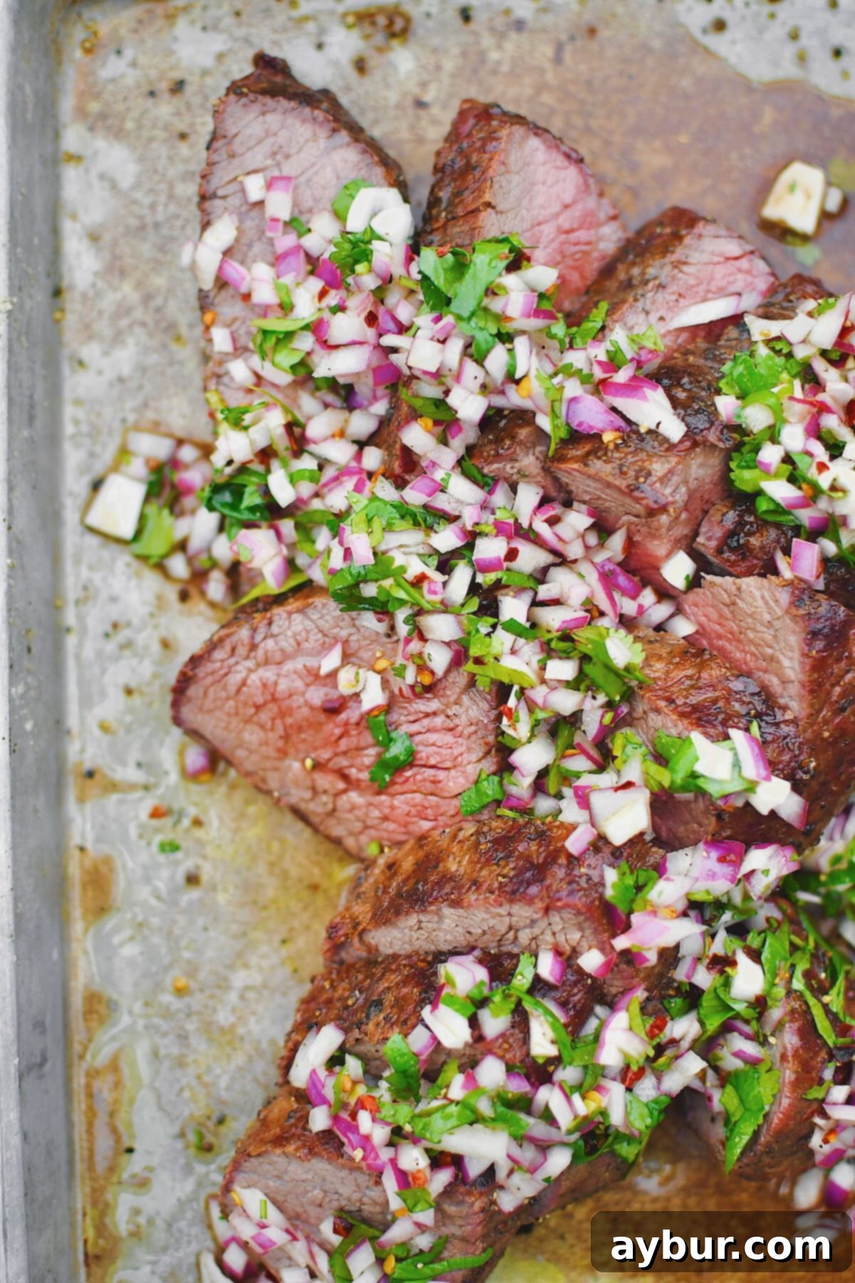 Perfect Tri-Tip Every Time 2 Tri-Tip, sliced against the grain, in two different directions, as is common with this cut of meat. Topped with an onion, cilantro, and vinegar relish.