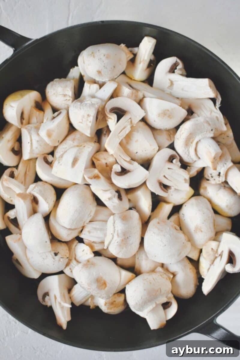 Caramelized Mushrooms and Onions 4 Fresh button mushrooms added to a hot skillet with olive oil, covered with a lid to steam.
