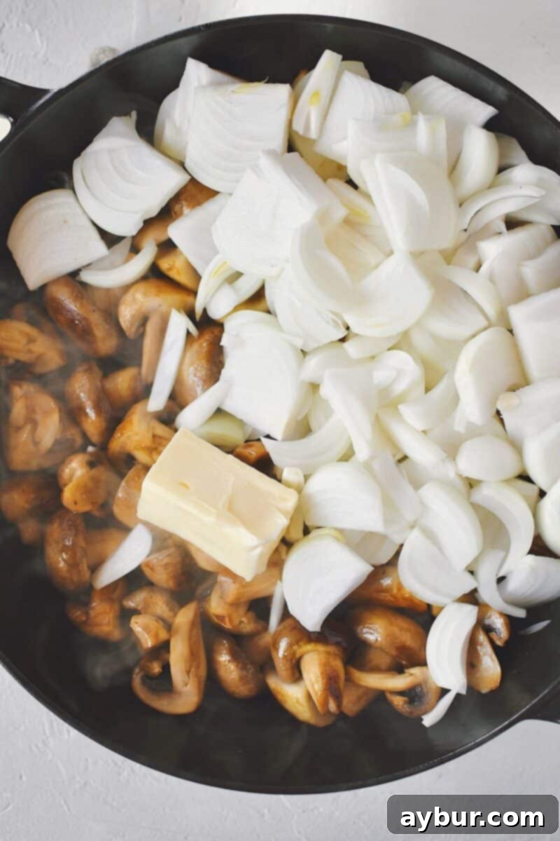 Caramelized Mushrooms and Onions 6 Sliced onions and butter being added to the sautéed mushrooms after their liquid has evaporated, ready for further cooking.