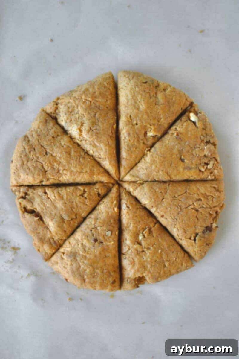 An overhead view of the scone dough, expertly patted out into a round disk and neatly cut into 8 wedges, poised for transfer to a baking tray before baking to golden perfection.