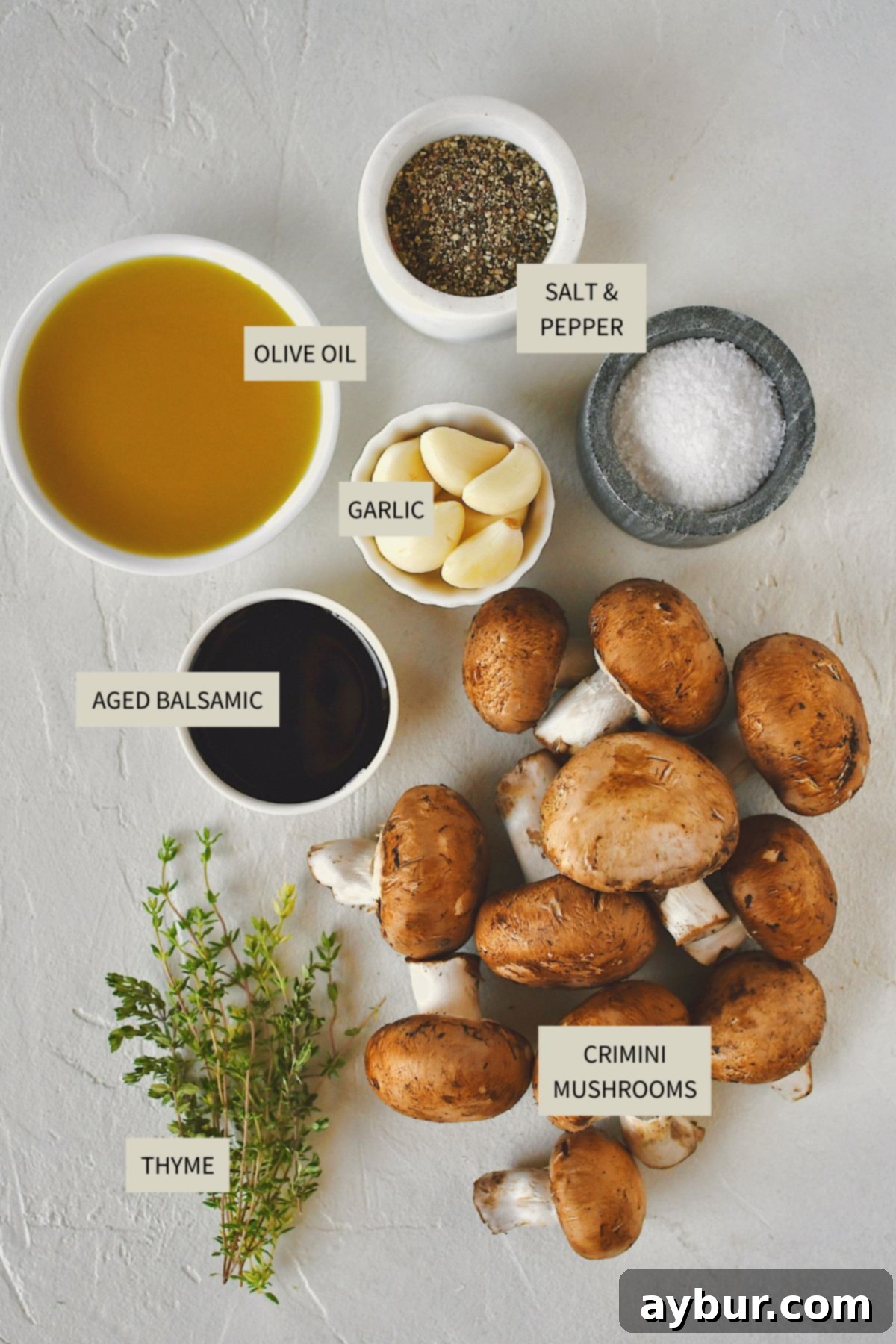 Earthy Roasted Delights 3 Fresh crimini mushrooms, olive oil, garlic, thyme, salt, and pepper laid out on a cutting board.