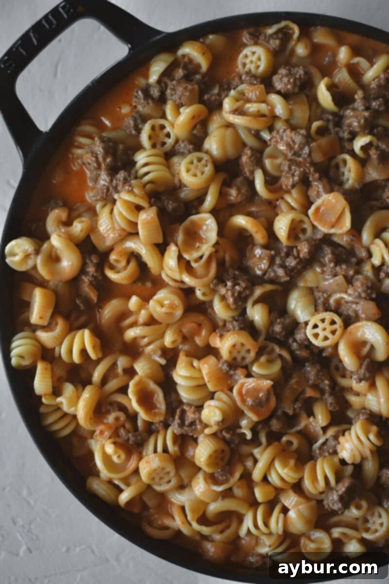 Pasta has been added to the pan along with some of the pasta water to finish the recipe.