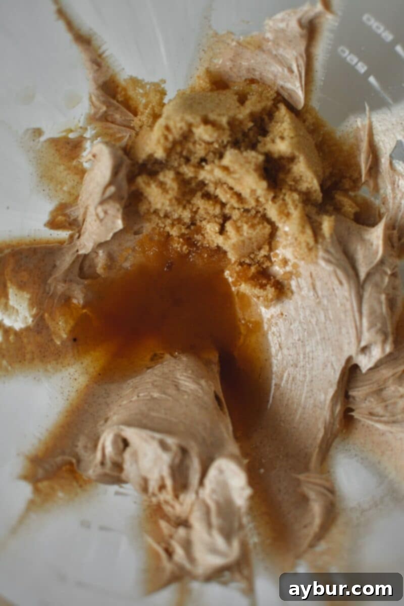 Sweet Cinnamon Butter 5 Rich brown sugar being gently added to the already whipped and fluffy mixture of butter, cinnamon, and honey in a stand mixer, preparing for the final blend.