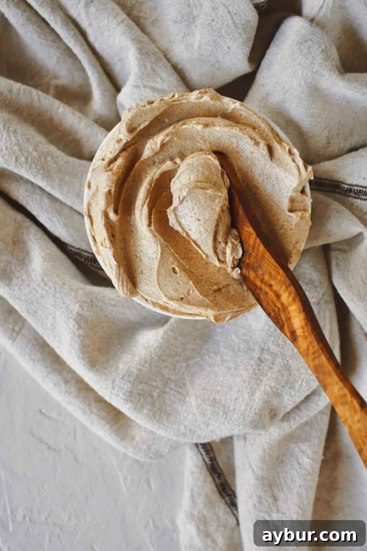 Sweet Cinnamon Butter 7 A beautifully composed shot of the whipped Cinnamon Butter in a shallow serving bowl, ready to be enjoyed. A wooden spreading knife rests invitingly, emphasizing its soft, spreadable texture and inviting appeal.