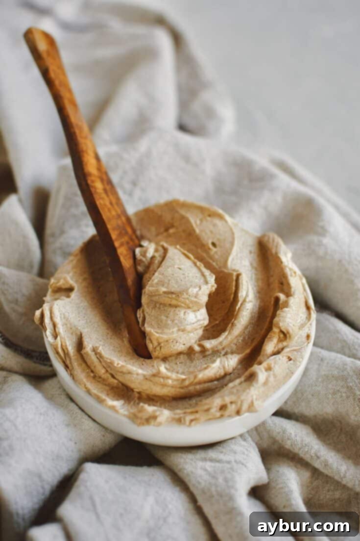 Sweet Cinnamon Butter 8 Cinnamon Butter that has been whipped to perfection, in a shallow bowl, with a wooden butter knife in it ready to be used.