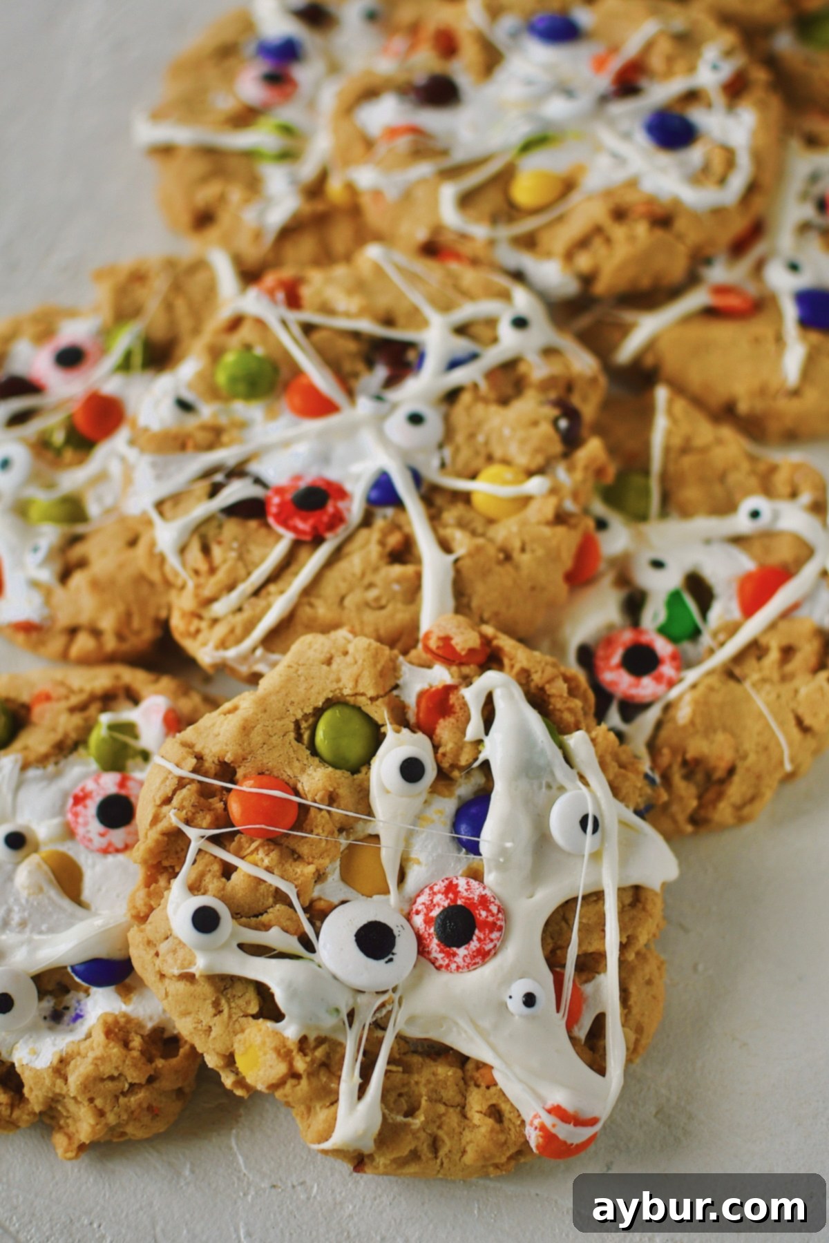 Peanut Butter Kitchen Sink Cookies 13 A close-up of Peanut Butter Monster Cookies with marshmallow webs and candy eyes, showcasing their detailed and festive Halloween design.