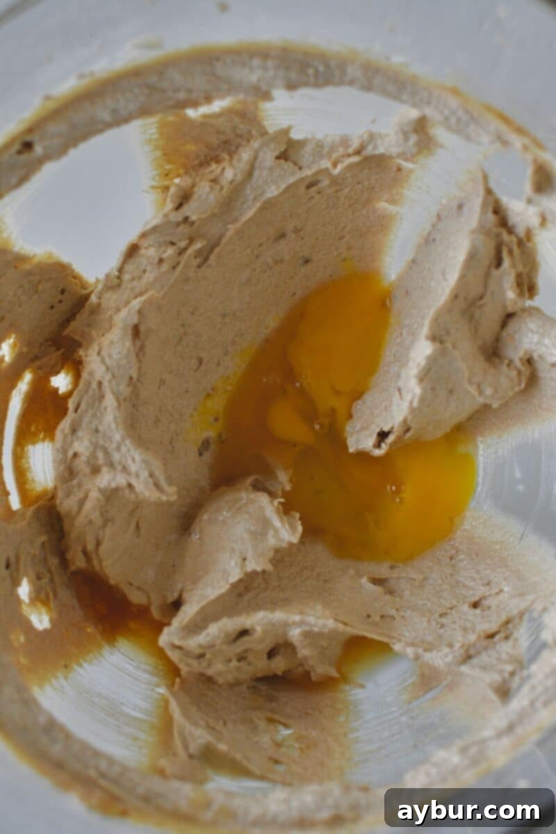 Peanut Butter Kitchen Sink Cookies 6 Creamed butters and sugars in the mixer bowl, with egg and vanilla extract being added for the next mixing stage.