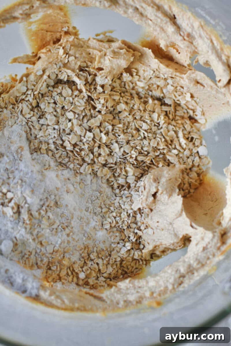 Peanut Butter Kitchen Sink Cookies 7 Adding all-purpose flour and quick cooking oats to the creamed butter and sugar mixture.