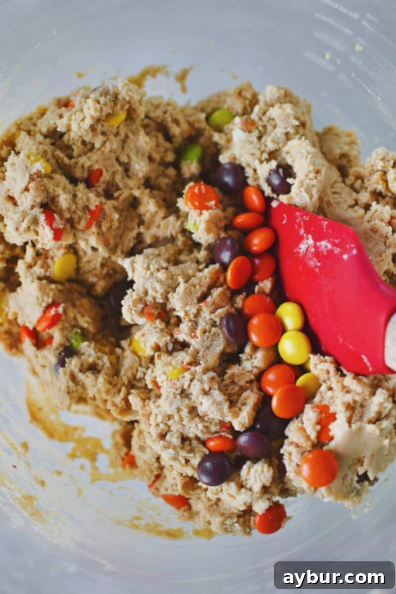 Peanut Butter Kitchen Sink Cookies 8 Gently folding in festive Halloween M&M candy and Reese's Pieces candy into the cookie dough.
