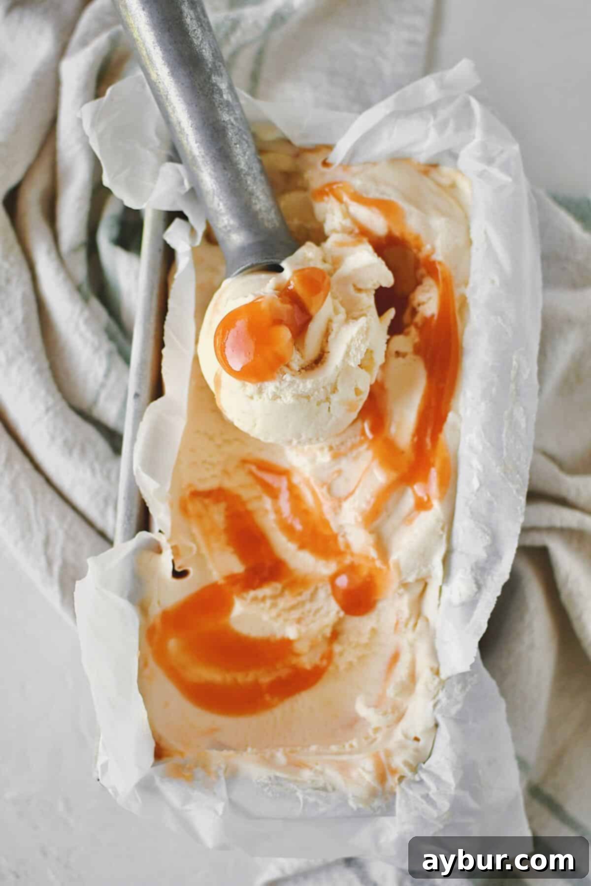 Sweet Peach Dream 14 A large scoop of peach ice cream in a serving bowl, ready to be enjoyed.