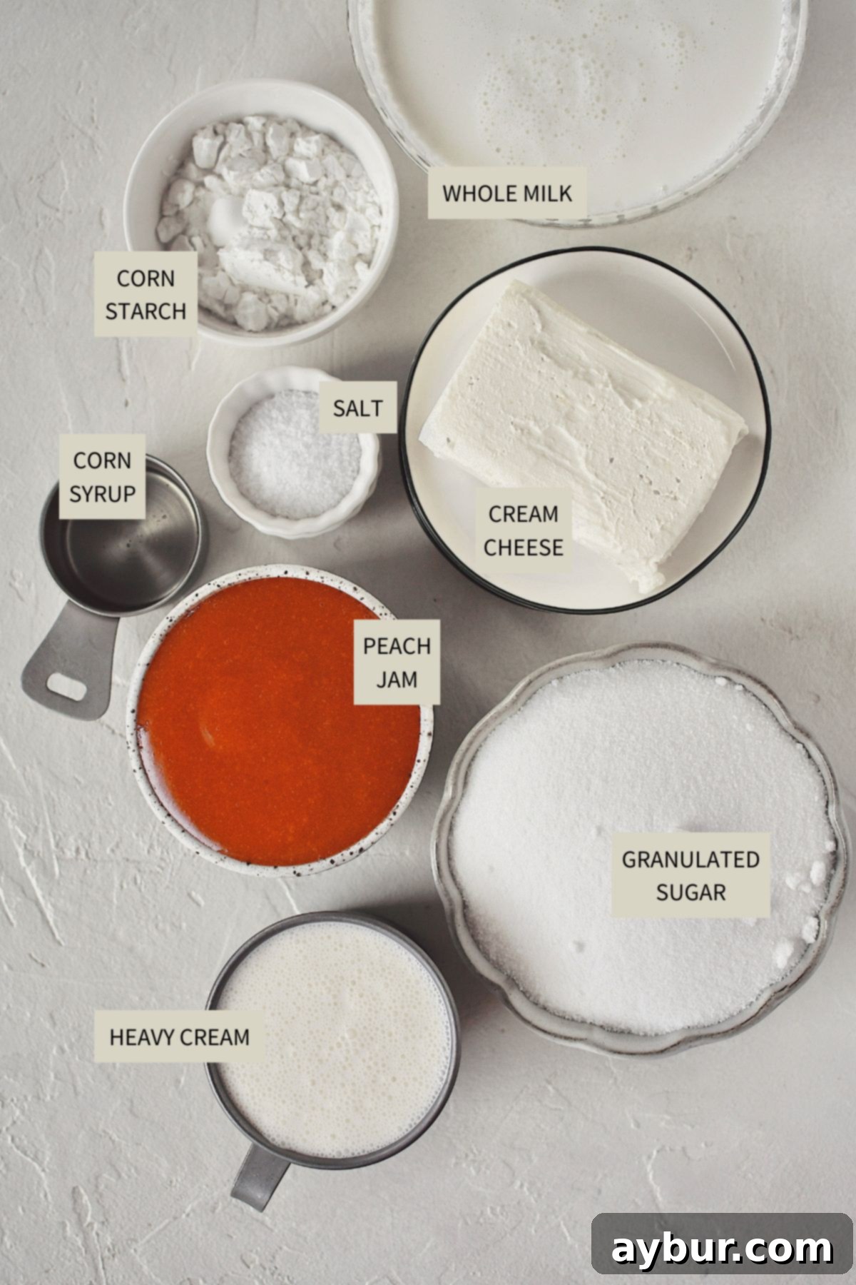 Sweet Peach Dream 3 A collection of ingredients laid out, including cream cheese, heavy cream, milk, sugar, corn syrup, and a jar of peach jam, ready to make peach ice cream.