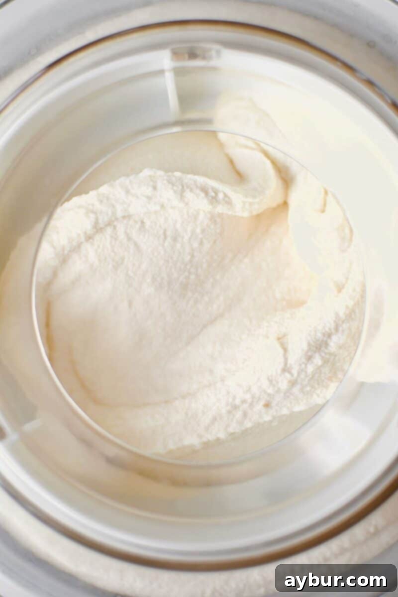 Sweet Peach Dream 9 The ice cream base after churning in an ice cream machine, showing its soft-serve consistency and readiness for freezing.