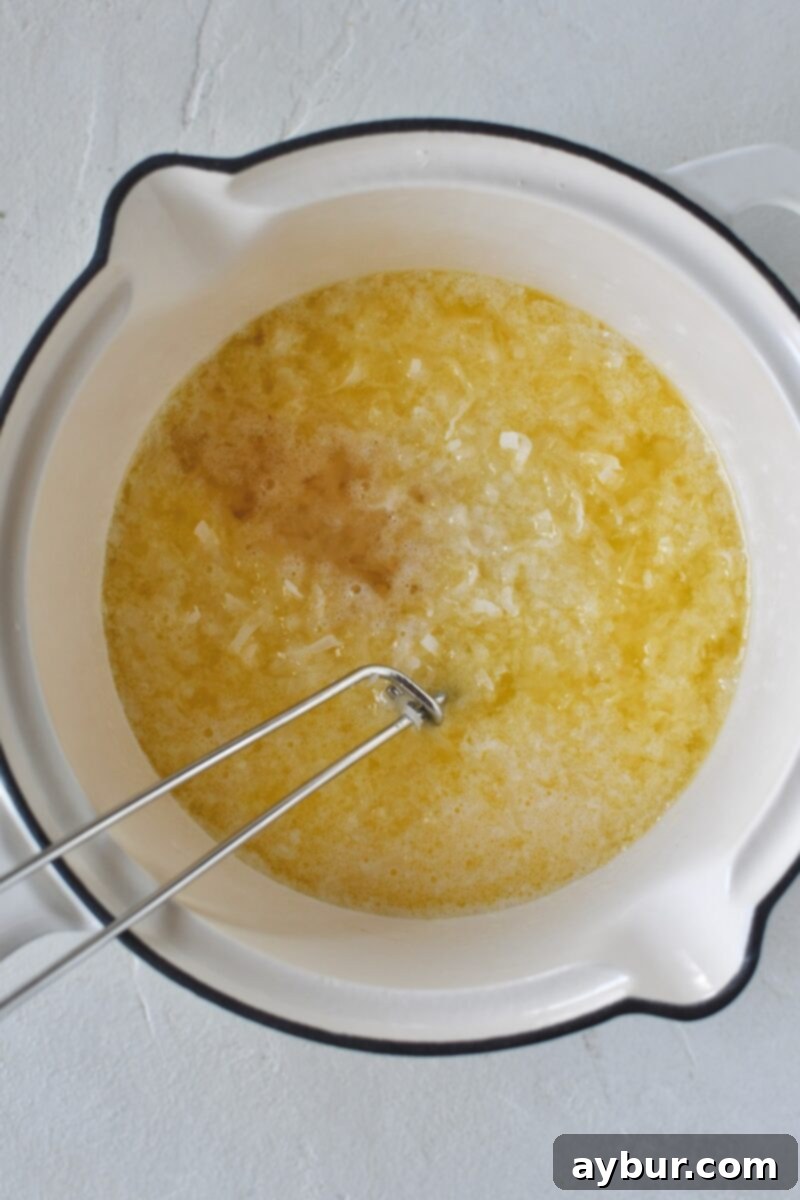 Warming the milk, and melting butter with the coconut, and extracts, before adding to the cake batter.