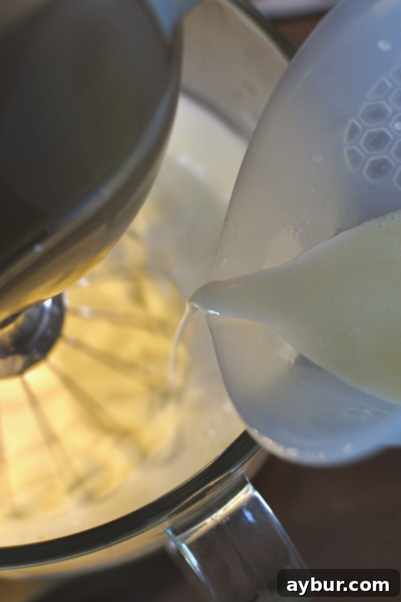 Adding in the warm coconut milk and butter mixture to the whipped eggs and sugar.