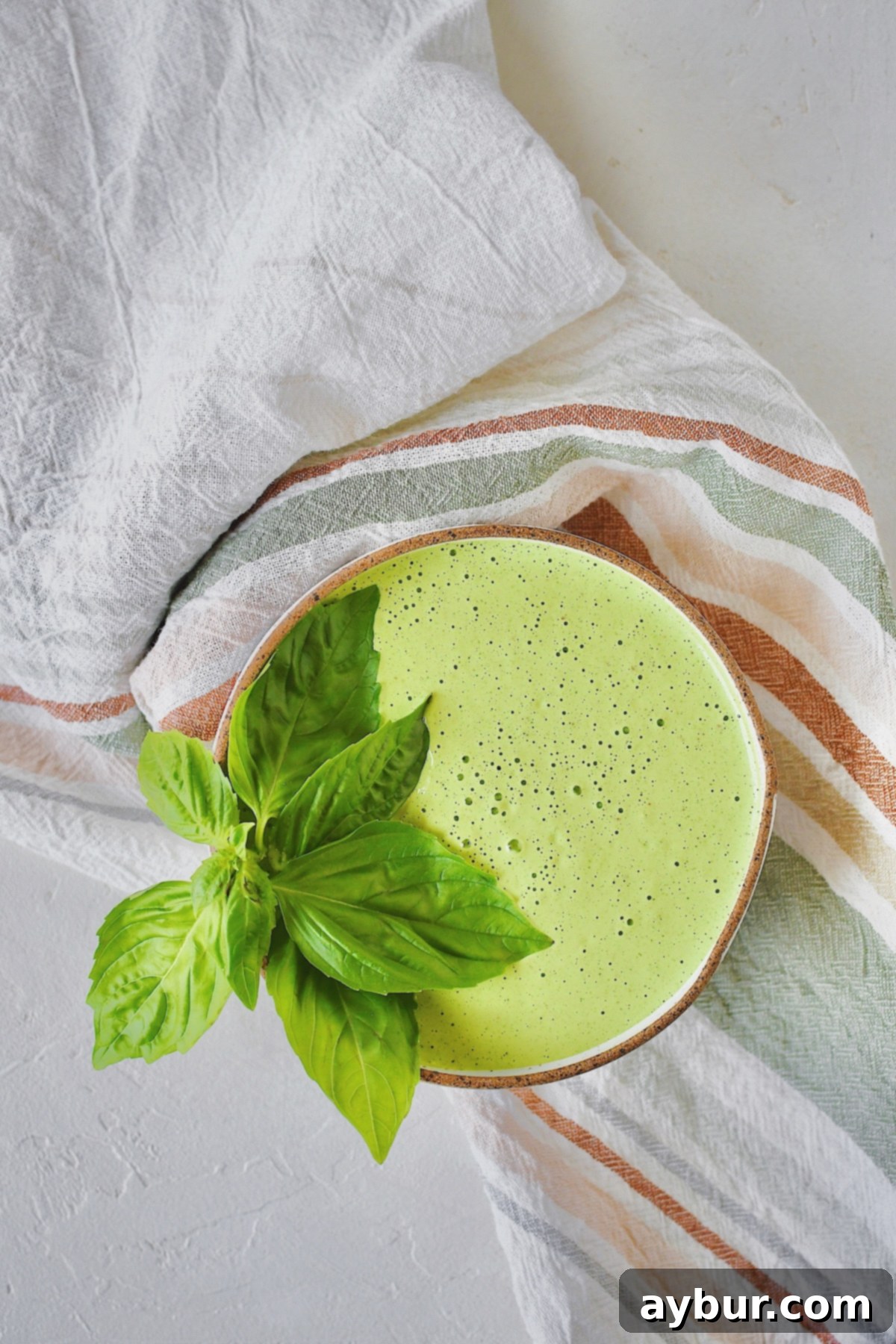 Green Goddess Dressing in a decorative bowl, perfectly smooth and ready to be drizzled over a salad.