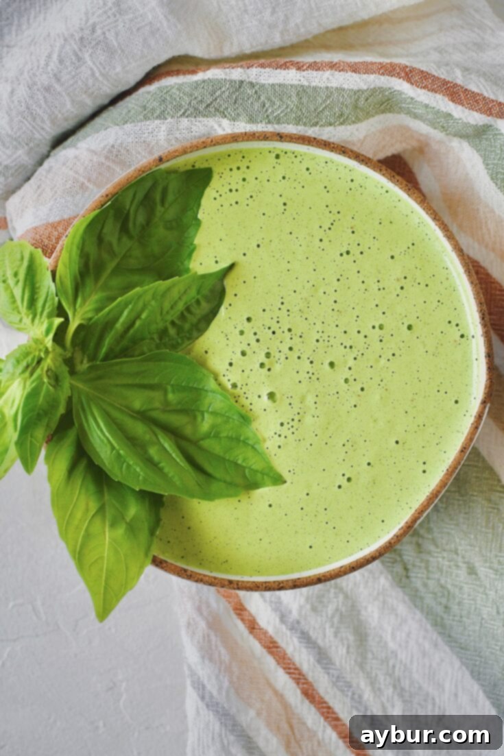 Green Goddess Dressing in a bowl, garnished with basil leaves and ready to be used.