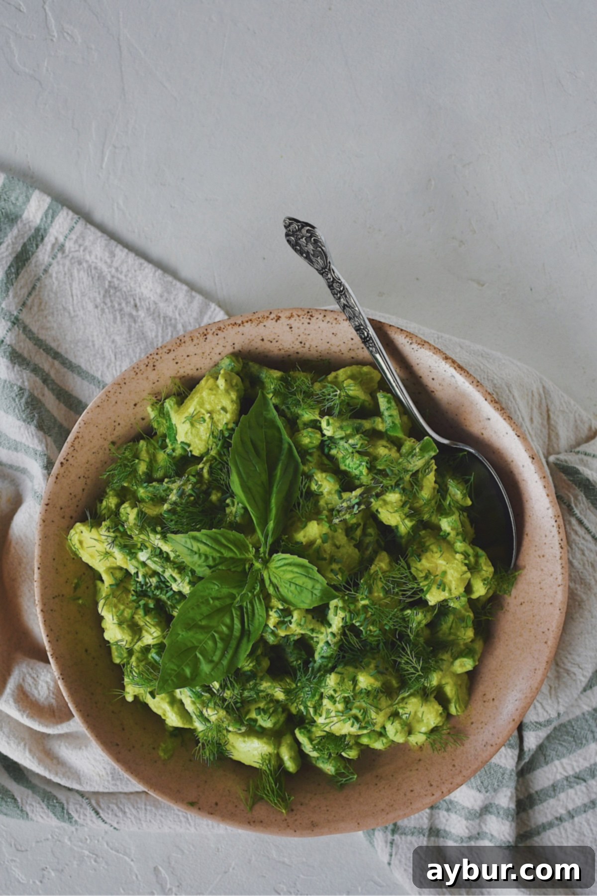 Vibrant Green Goddess Potato Salad 2 Green Goddess Potato Salad in a beautiful serving bowl, garnished with fresh herbs, with a large spoon ready to serve.