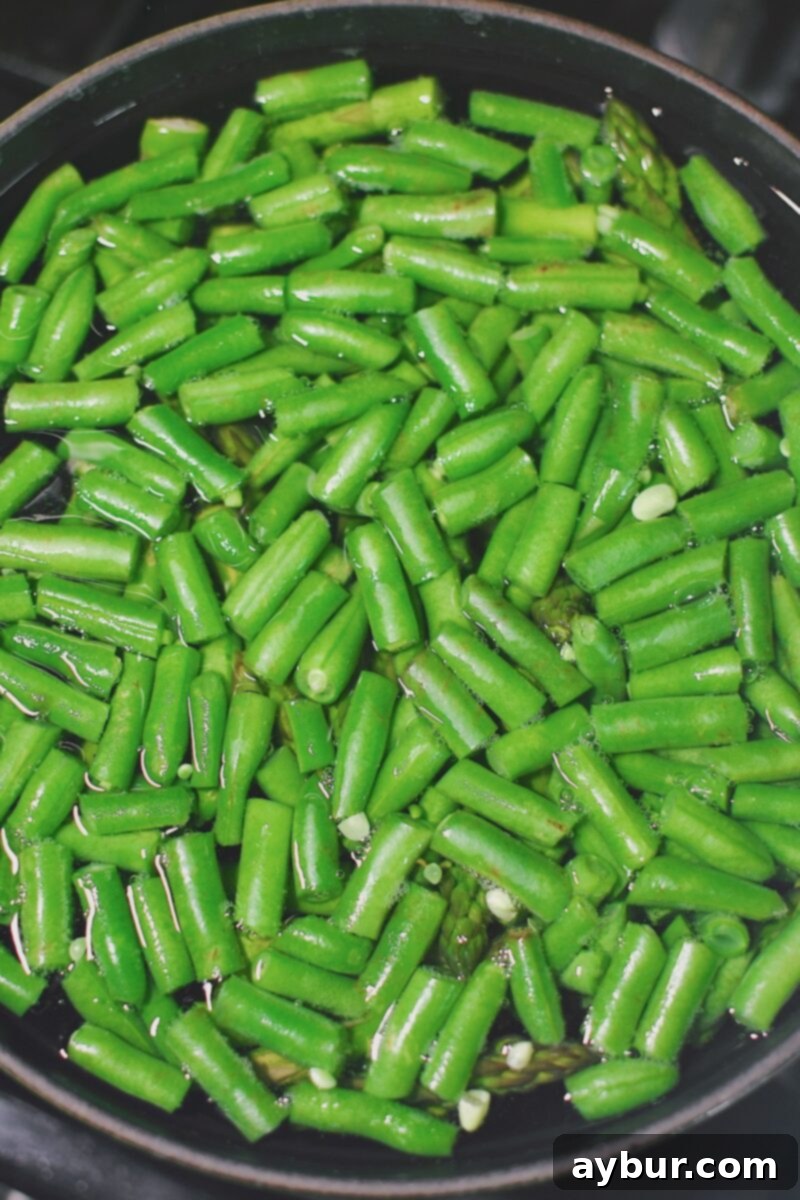 Vibrant Green Goddess Potato Salad 4 Blanching green beans and asparagus in a pot of heavily salted boiling water until just crisp-tender, before shocking them in ice water.