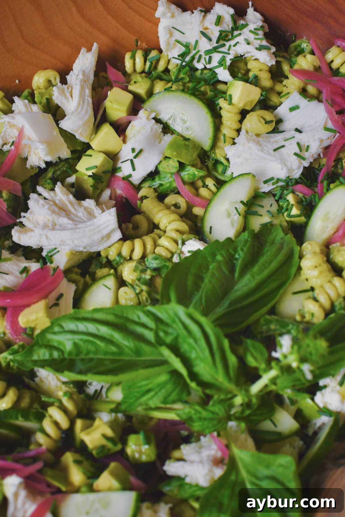 Vibrant Green Goddess Pasta 12 A close-up view looking into the serving bowl of the vibrant Green Goddess Pasta Salad, highlighting the fresh ingredients and creamy dressing.