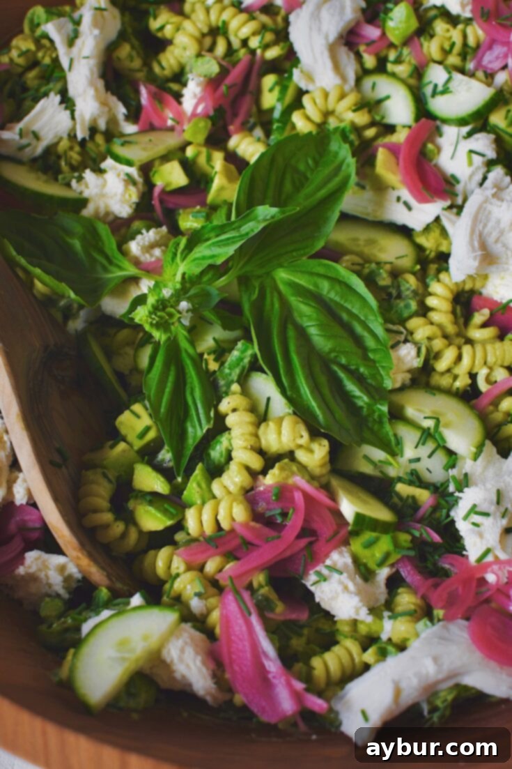 Vibrant Green Goddess Pasta 13 Close up of vibrant Green Goddess Pasta Salad in a large wooden bowl, garnished and ready to serve.