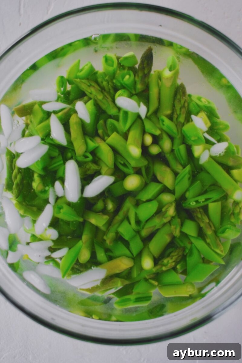 Vibrant Green Goddess Pasta 6 The blanched vegetables being removed from the boiling water and immediately transferred to an ice bath to preserve their color and texture.