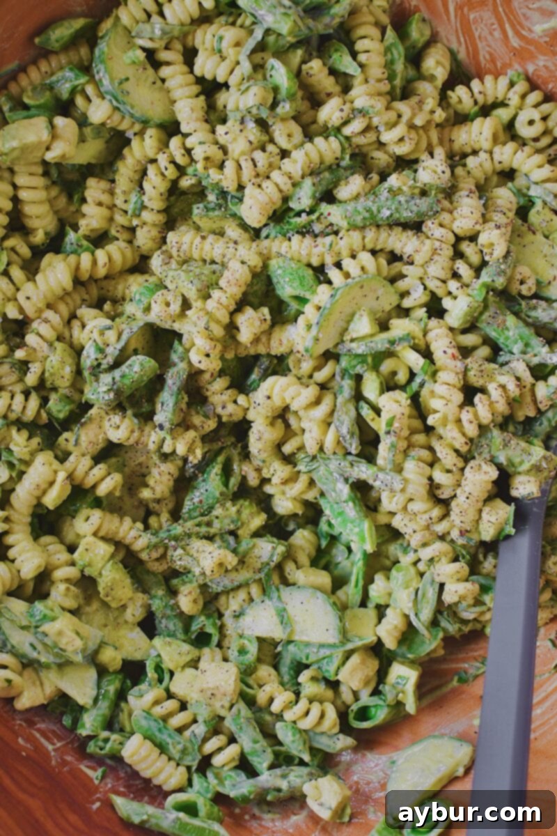 Vibrant Green Goddess Pasta 9 All the vibrant Green Goddess Pasta Salad ingredients tossed together in a large mixing bowl, beautifully coated in dressing.