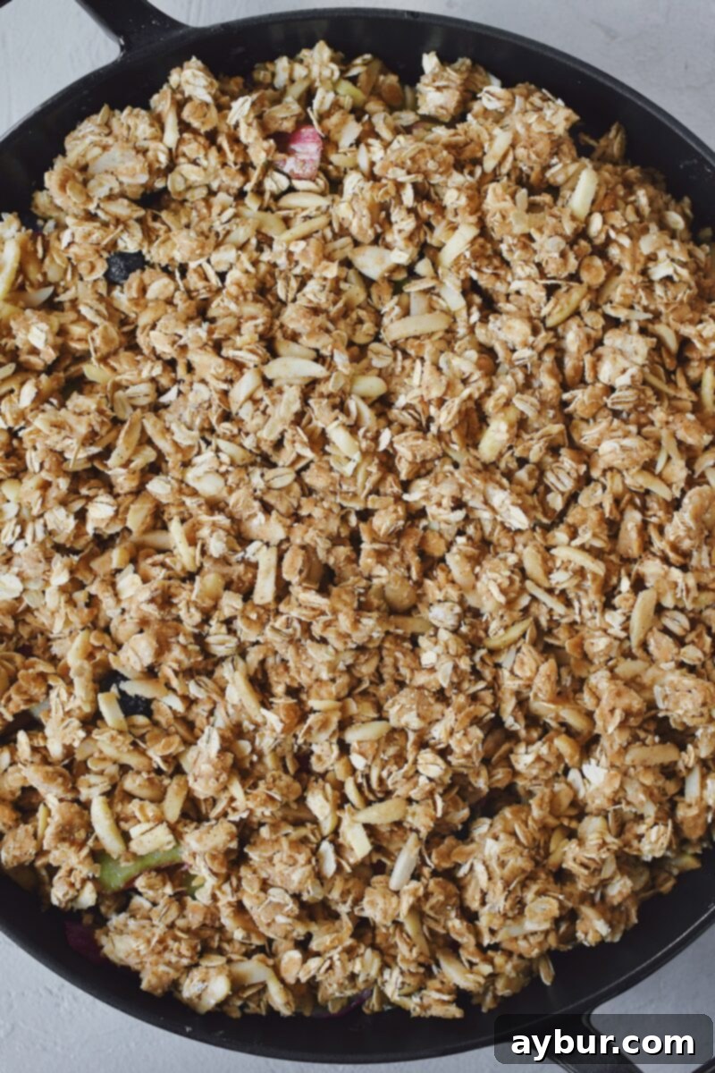 Berry and rhubarb mixture placed in a large skillet, crisp topping added.