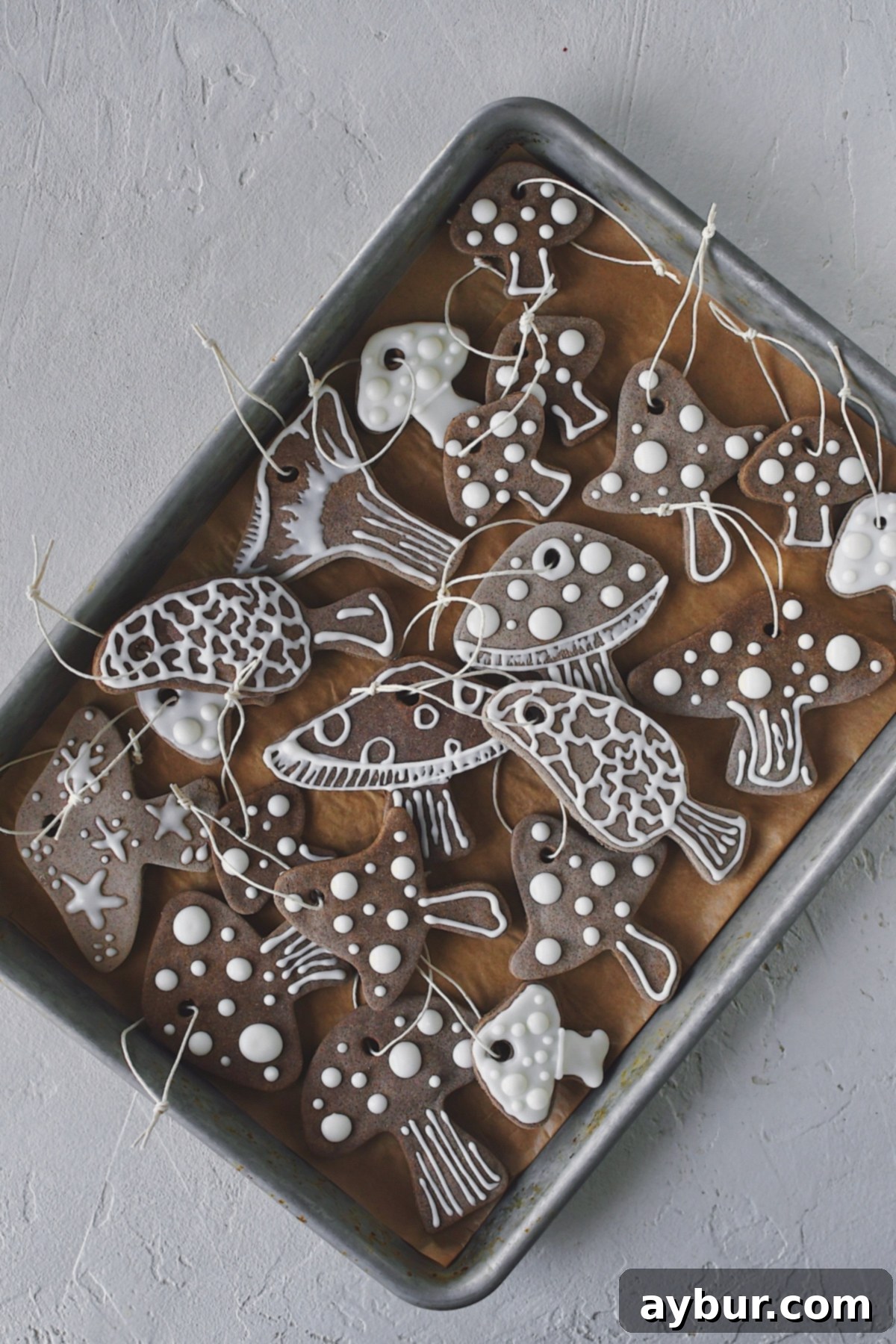 Salt Dough Gingerbread Keepsakes 2 Strings attached to dried and decorated Gingerbread Salt Dough Ornaments, many different designs, all laid on a tray ready to be hung on a tree.