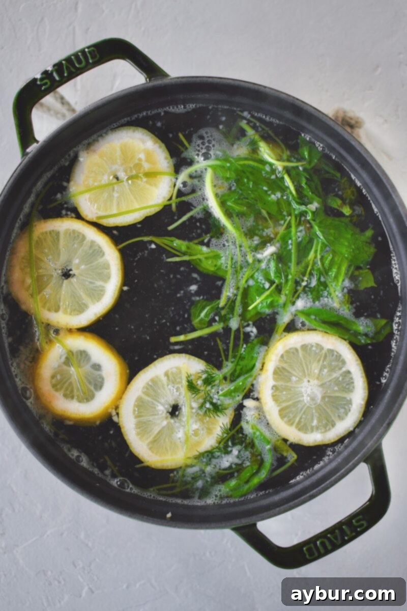 Poaching liquid simmering in a pot, filled with vibrant lemons, fresh herbs, and chopped garlic.