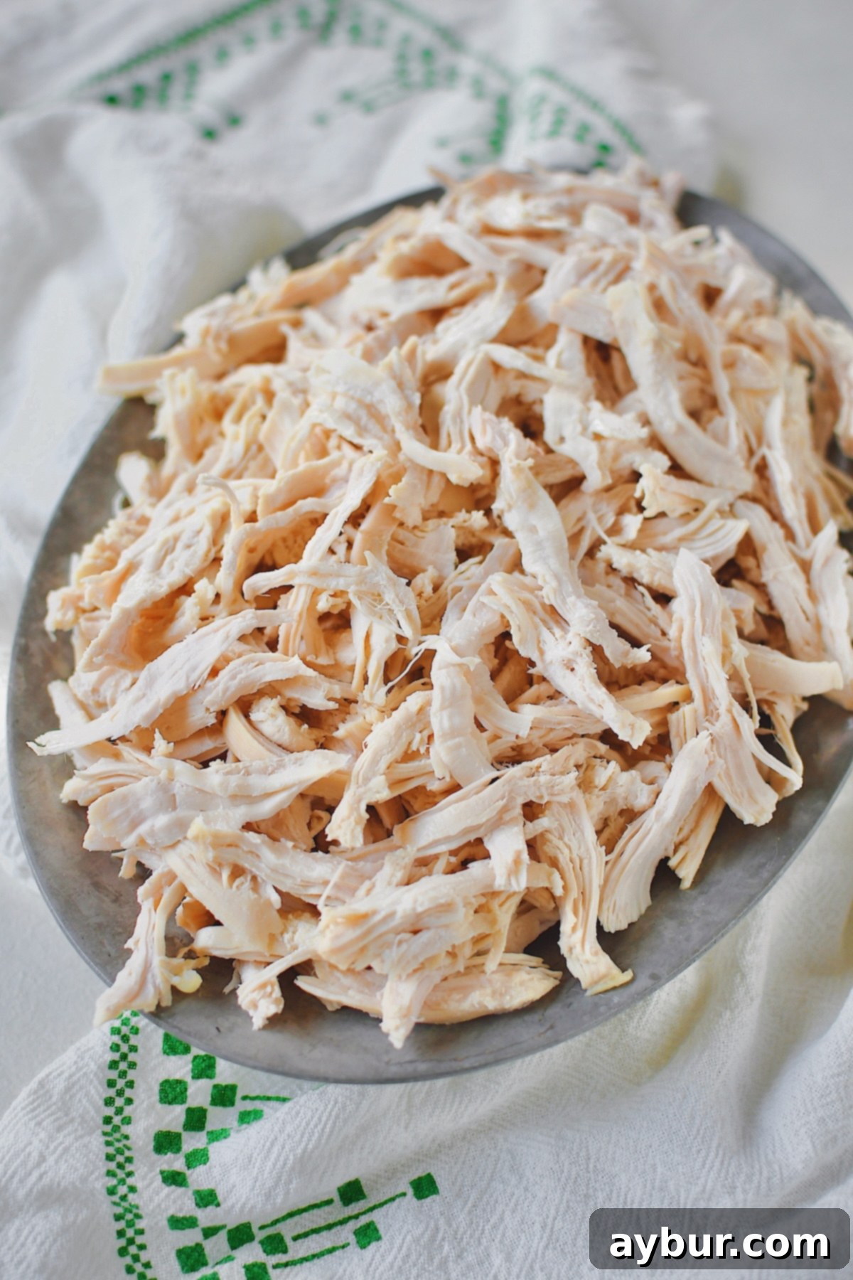 Shredded poached chicken piled high, ready to be incorporated into various delicious meals.