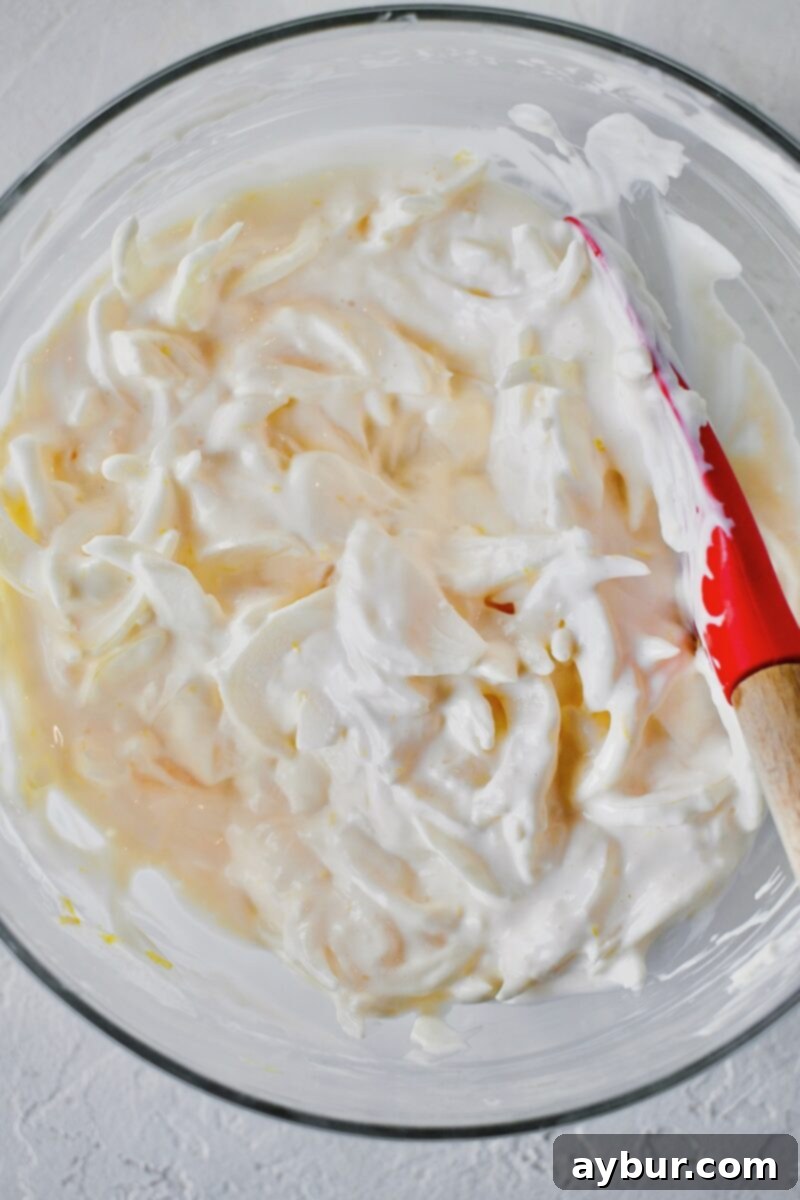 The mayonnaise, vodka, and vermouth are vigorously stirred into the onion mixture to form a creamy, cohesive dressing.