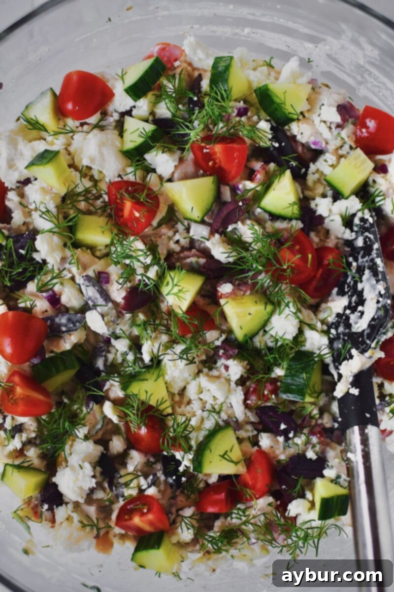 Finished Greek Style Chicken Salad, presented beautifully in a bowl, ready to be enjoyed as a dip with pita chips or as a sandwich filling.