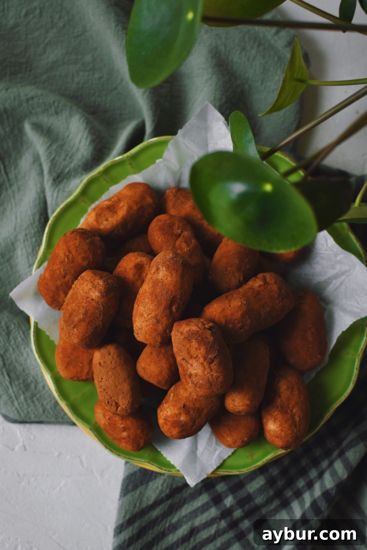Stacked up on a green plate, the Irish Potato Candy is ready to serve.