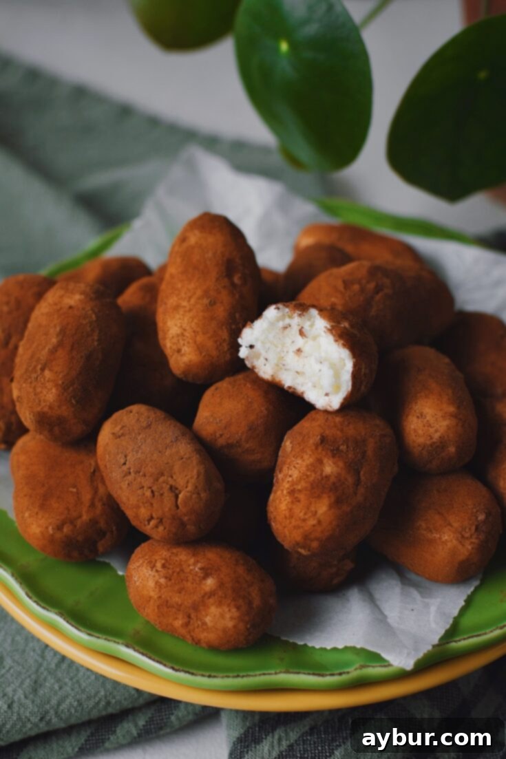 A stack of Irish Potato Candy with one on top that has a bite taken from it!
