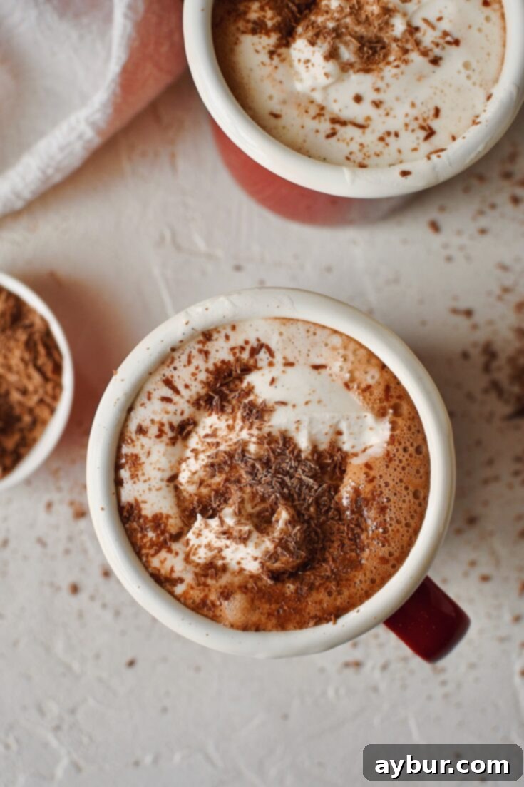 Simple 3-Ingredient Nutella Hot Chocolate 3 Two mugs of creamy Nutella Hot Chocolate, generously topped with fluffy whipped cream and delicate chocolate shavings.