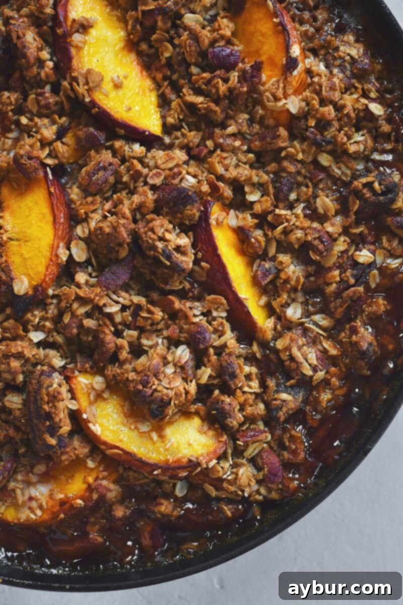 Close-up view of the perfectly baked Peach Pecan Crisp, golden-brown and steaming.