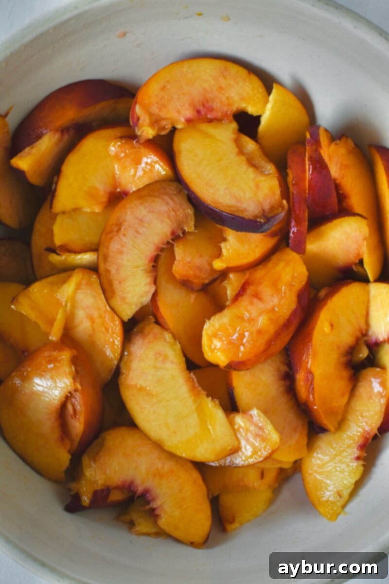 Freshly sliced peaches, vibrant and ready, in a large mixing bowl.