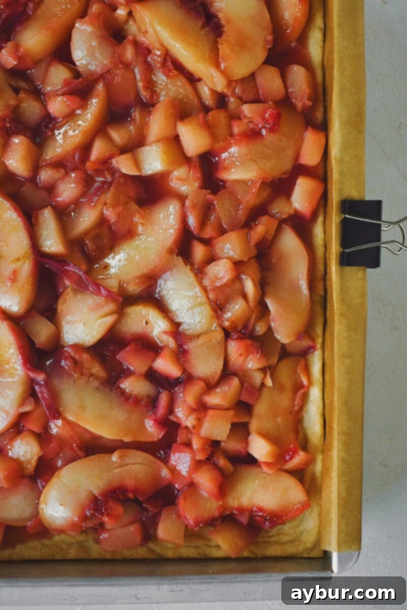 Cooked peaches spread smoothly over the pre-baked shortbread base.