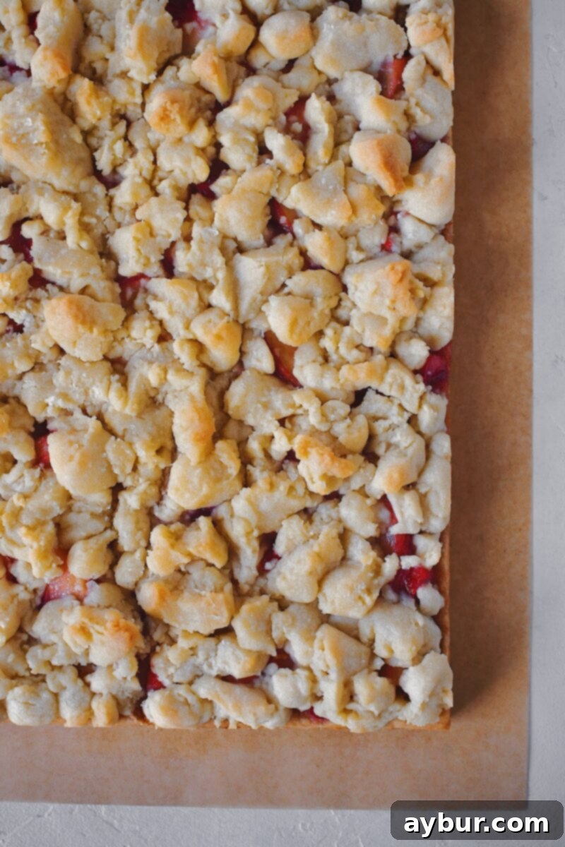 Baked and cooled bars being lifted out of the baking pan using parchment paper.