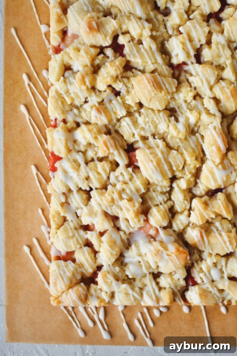 Baked Peach Shortbread Bars on a cutting board, after being drizzled with icing.