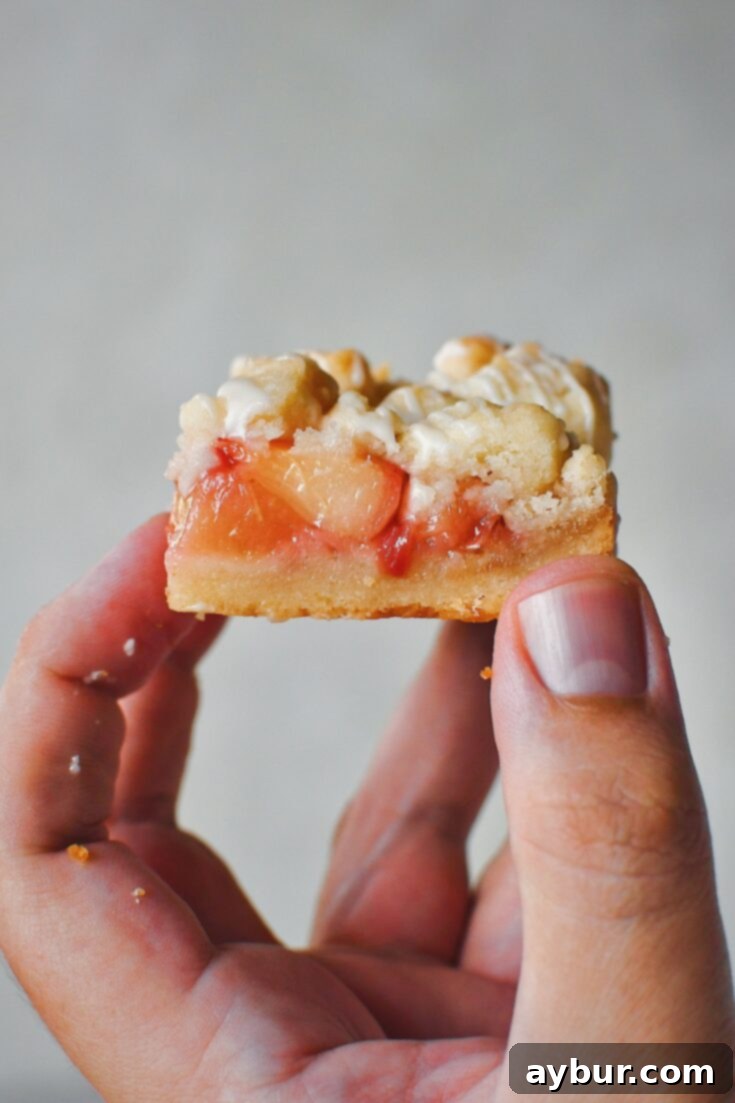 Holding one of the White Peach Bars in hand, side exposing all three layers.