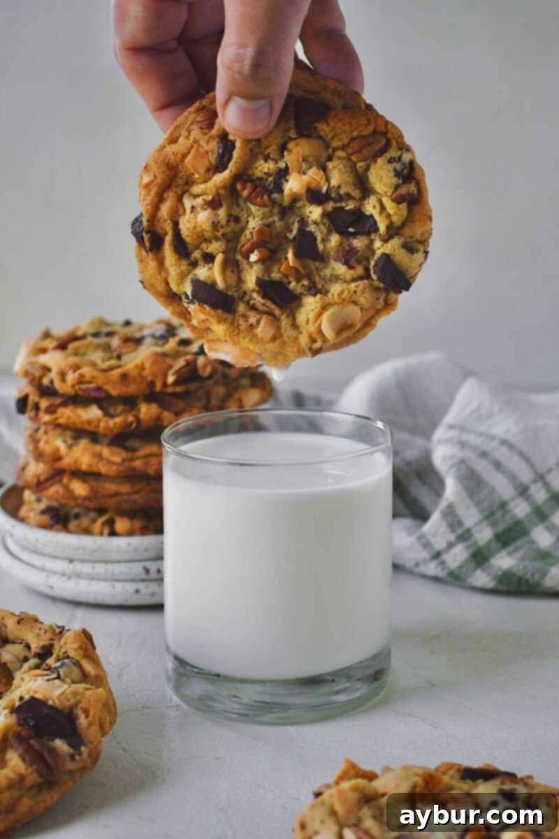 The delicious aftermath: a giant Coconut Pecan Chocolate Chip Cookie, slightly softened by a dip in cold milk, ready for the next delightful bite.