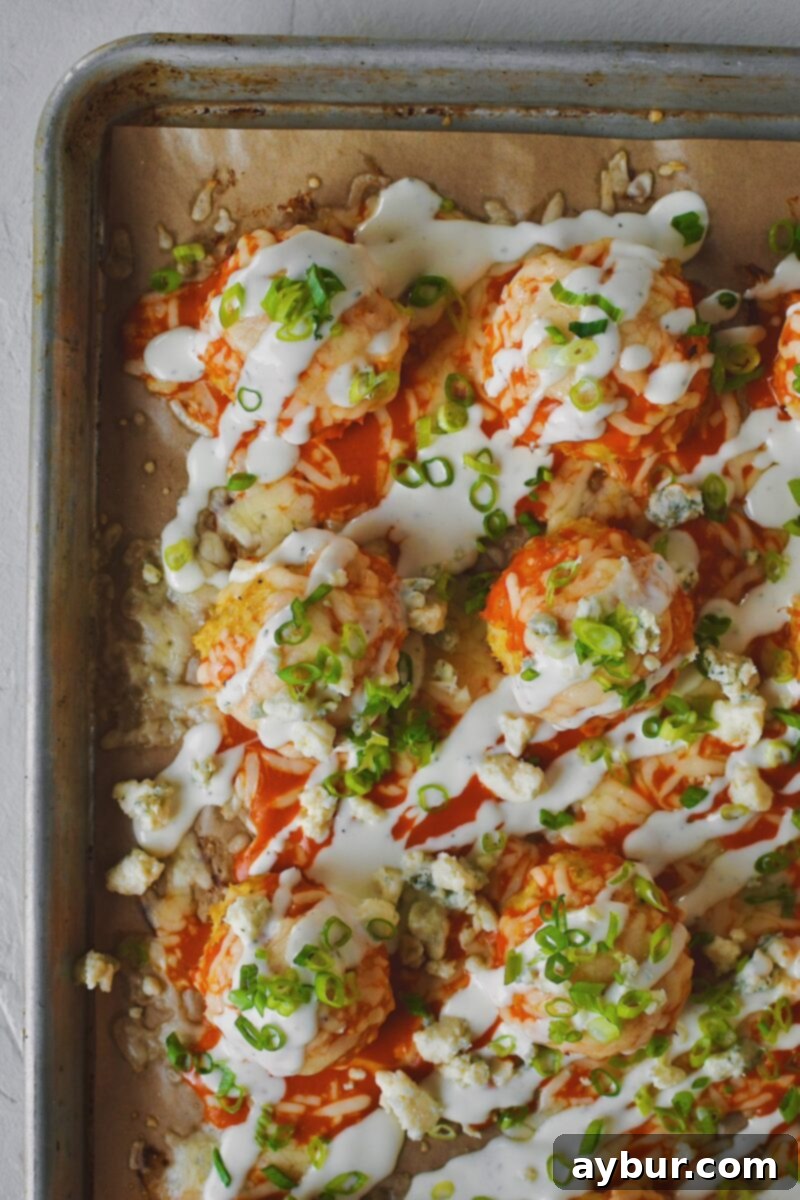 After melting the cheese, Buffalo Chicken Meatballs just out of the oven and topped with ranch dressing and chopped green onions.