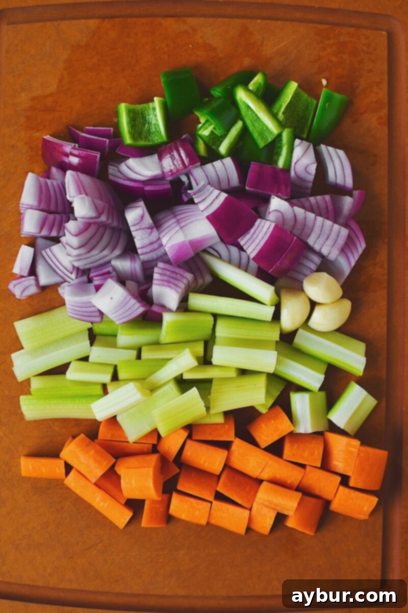 Spicy Buffalo Chicken Meatballs 4 Diced Jalapeno, red onion, celery, and carrot on a cutting board with 3 cloves of garlic.
