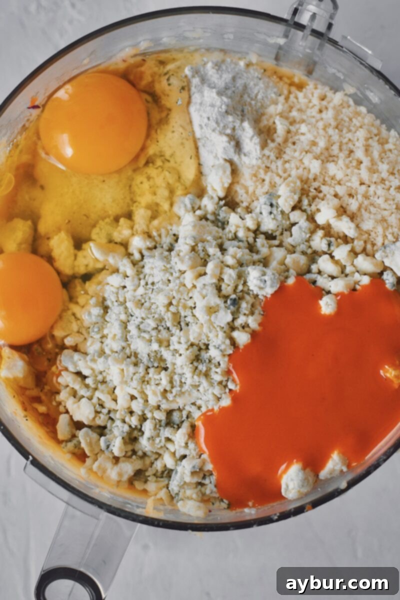 Spicy Buffalo Chicken Meatballs 7 Adding the eggs, ranch seasoning, blue cheese, buffalo sauce, and bread crumbs into the chicken mixture.