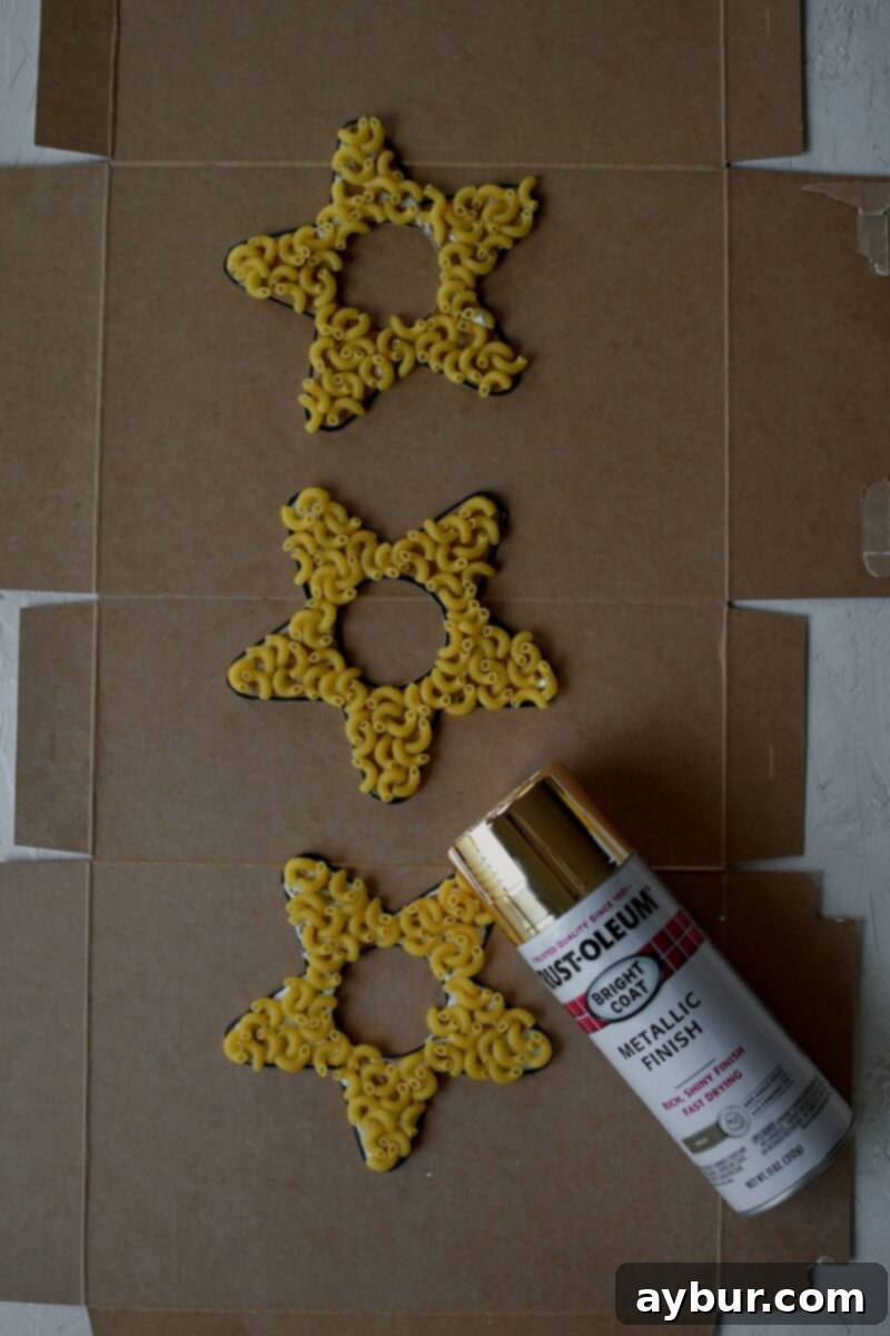 Macaroni pasta has all been glued on, before spray painting gold.